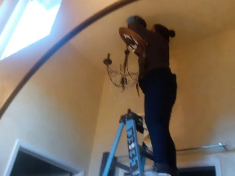 Electrician installing a chandelier in a Wytheville residence